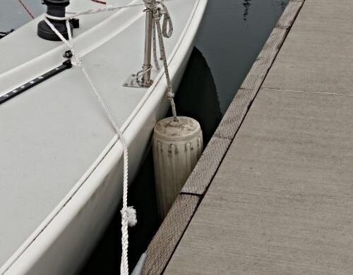 Seilbåt fortøyd langs brygge med springline og fender