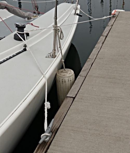 Seilbåt fortøyd langs brygge med springline og fender