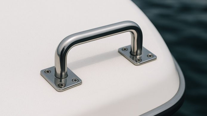 Elegant, svart håndtak med diskret festemekanisme montert på en hvit vegg.